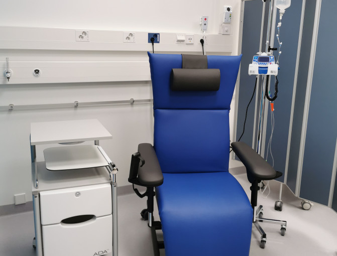 Sininen potilastuoli, tippateline ja valkoinen pöytä.
