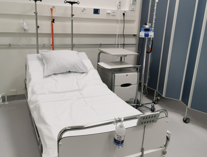 Sairaalasänky, valkoinen pöytä ja tippateline, jossa on tippalaskuri.